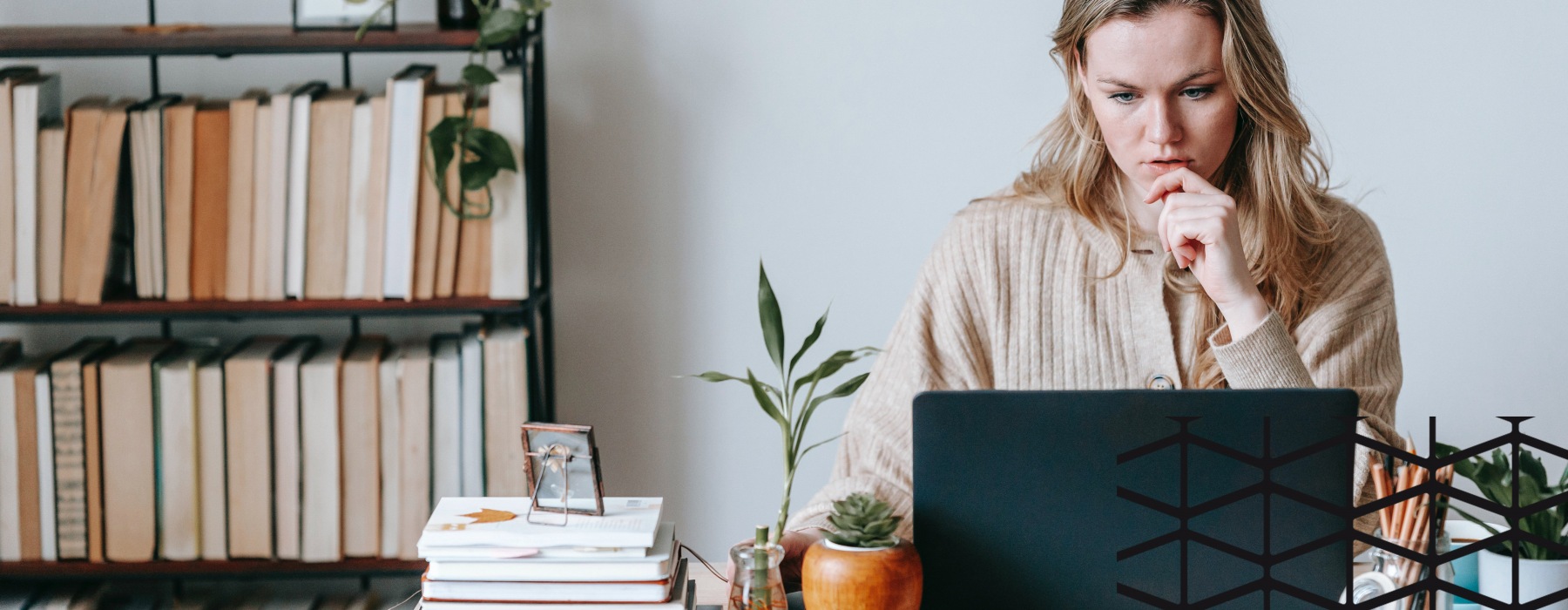woman sits at her desk and works on laptop